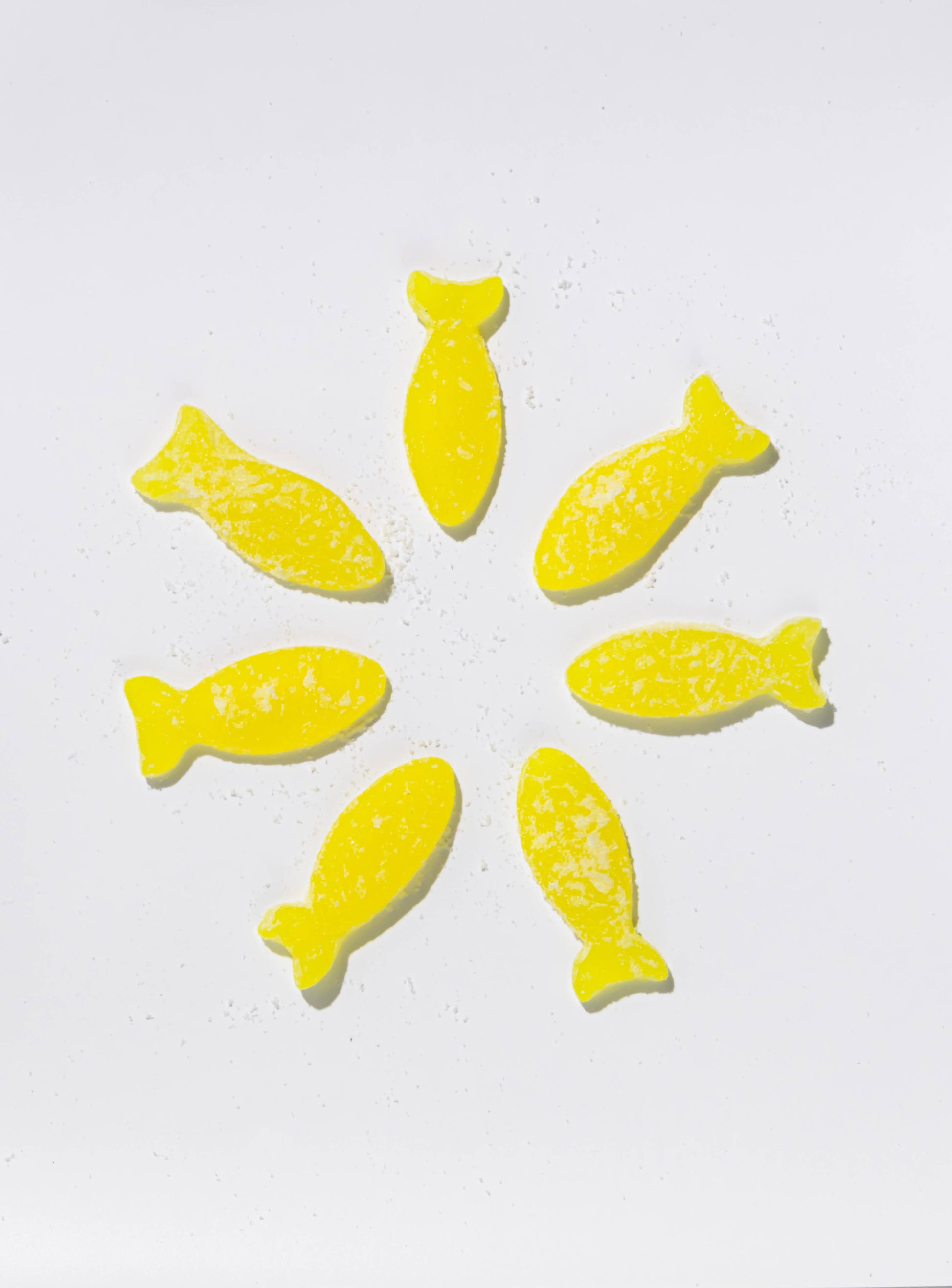 Yellow fish-shaped candies on a white background